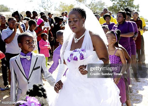 Anele Masilela, a nine year-old watches as his wife Helen Shabangu, 62 year-old kisses her 'real life' husband Abel, at their white wedding on July...