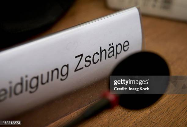 Sign and a microphone sit on the table of co-defendant Beate Zschaepe as she prepares for today's NSU neo-Nazi murders trial on November 27, 2013 in...