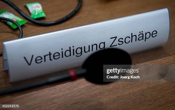 Sign and a microphone sit on the table of co-defendant Beate Zschaepe as she prepares for today's NSU neo-Nazi murders trial on November 27, 2013 in...