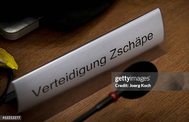 Sign and a microphone sit on the table of co-defendant Beate Zschaepe as she prepares for today's NSU neo-Nazi murders trial on November 27, 2013 in...