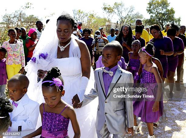 Anele Masilela, a nine year-old watches as his wife Helen Shabangu, 62 year-old kisses her 'real life' husband Abel, at their white wedding on July...