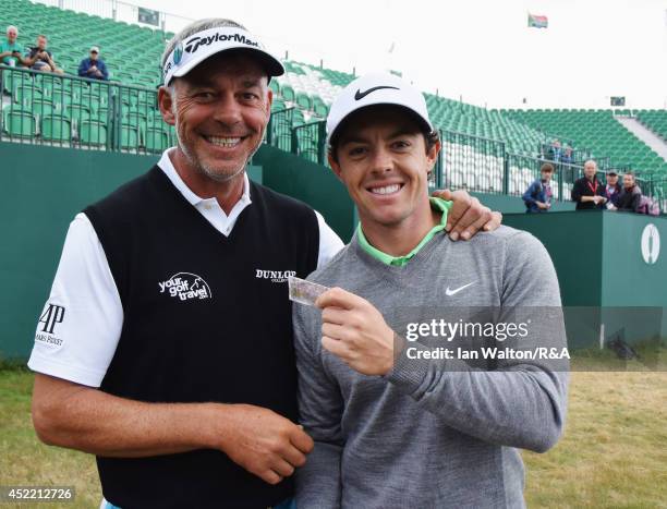 Rory McIlroy of Northern Ireland celebrates winning a bet against Darren Clarke of Northern Ireland after their practice round prior to the start of...