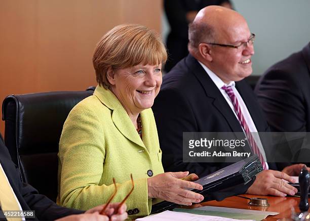 German Chancellor Angela Merkel and Minister of the Chancellery Peter Altmeier arrive for the weekly German federal Cabinet meeting on July 16, 2014...