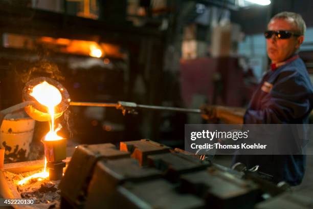 Employee taking a sample of liquid iron at the Ortrander Eisenhuette GmbH, an ironworks on July 03 in Ortrand, Germany. The ironworks manufactures...