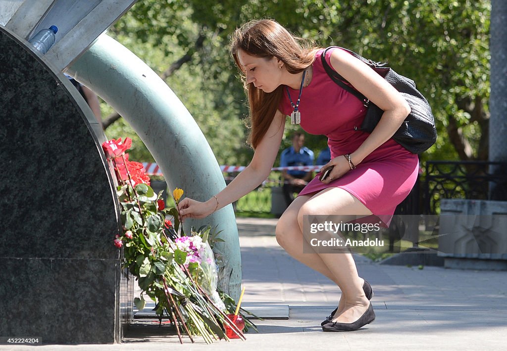 People lay flowers the entrance of metro stations