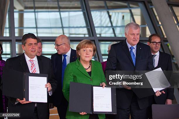Sigmar Gabriel, head of the Social Democratic Party , left, stands with Angela Merkel, Germany's chancellor, center, and Horst Seehofer, who heads...