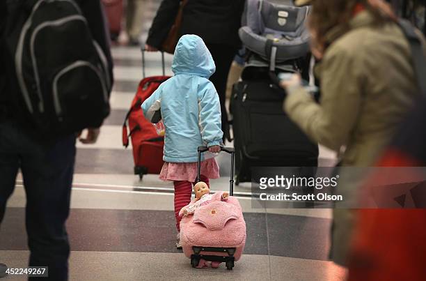 Travelers arrive for holiday flights at O'Hare International Airport on November 27, 2013 in Chicago, Illinois. Nearly 1.5 million travelers are...