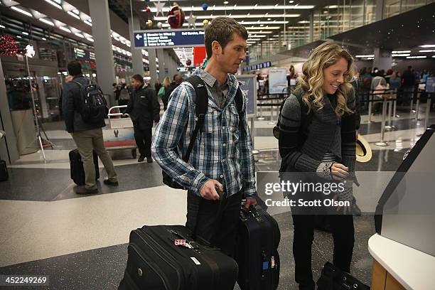 Jon Roeker and Lindsay Jones check in for a flight to Jamaica at O'Hare International Airport on November 27, 2013 in Chicago, Illinois. Nearly 1.5...
