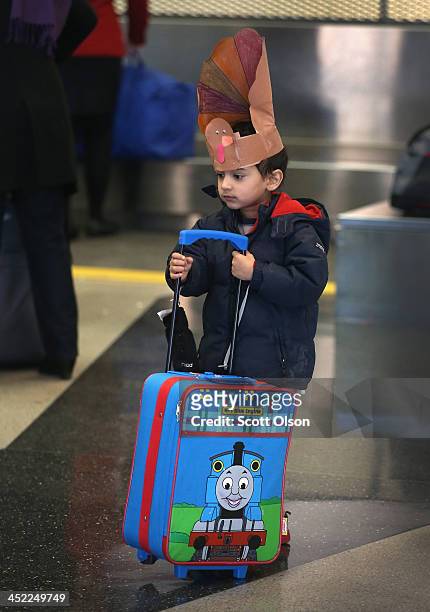 Rabi Chandra waits as his parents check in for a flight at O'Hare International Airport on November 27, 2013 in Chicago, Illinois. Nearly 1.5 million...