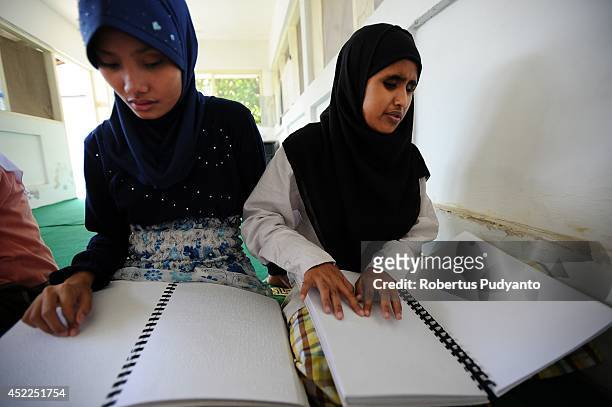Visually impaired students read a Braille Quran at The Foundation for The Education of Blind Children during Ramadan on July 17, 2014 in Surabaya,...