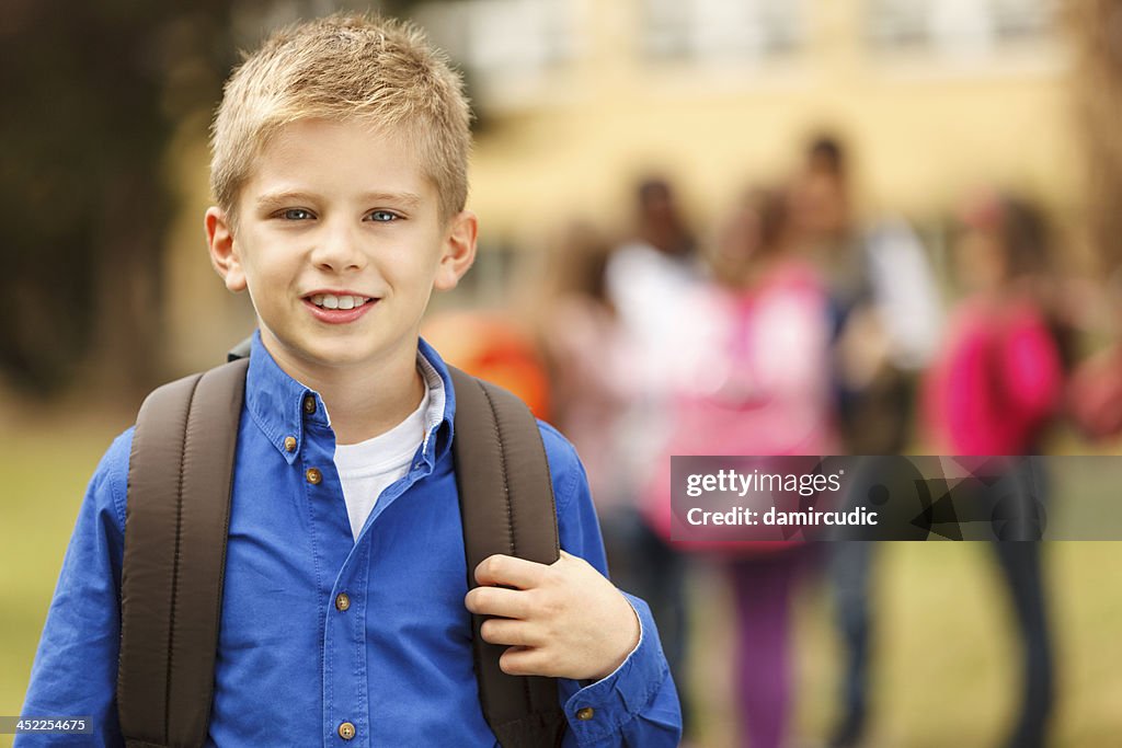 Schoolboy in front of the school