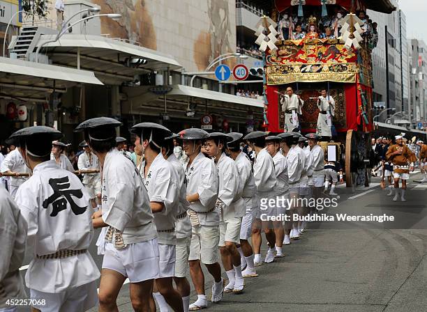 Japanese men dressed in traditional costumes tow a festival cart named Yamahoko during the annual Kyoto Gion Festival on July 17, 2014 in Kyoto,...