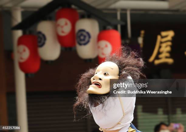 Japanese man dressed in traditional mask walks in the street during the annual Kyoto Gion Festival on July 17, 2014 in Kyoto, Japan. The Gion...