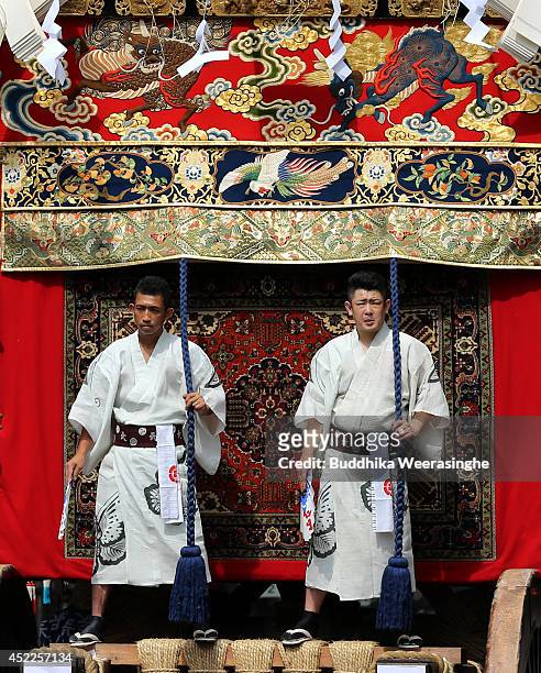 Japanese men dressed in traditional costumes stand on the festival cart named Yamahoko during the annual Kyoto Gion Festival on July 17, 2014 in...