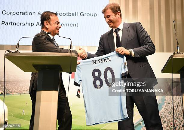Ferran Soriano , CEO of City Football Group, which owns Manchester City Football Club, gives a Manchester City shirt to Carlos Ghosn , CEO and...