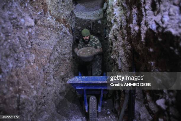 Member of the Islamist rebel group Al-Nusra Front fills a cart with sand as the group alledgely digs a tunnel under a military site of the Syrian...