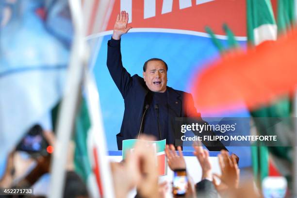 Italy's former Prime Minister Silvio Berlusconi waves to supporters at the end of his speech outside his private residence, the Palazzo Grazioli,...