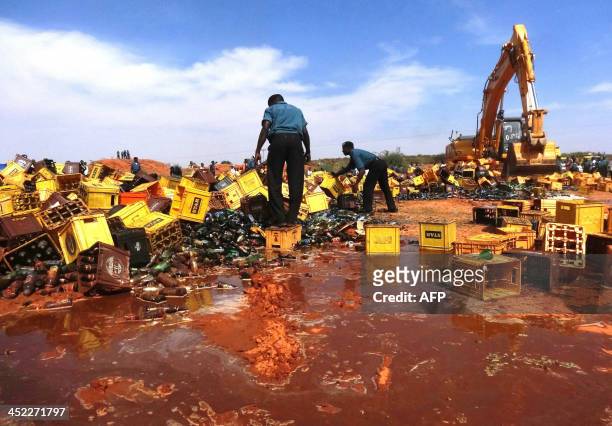 Sharia enforcers called Hisbah destroy thousands of bottles of beer outside northern Nigeria's largest city of Kano on November 27, 2013. The Hisbah...
