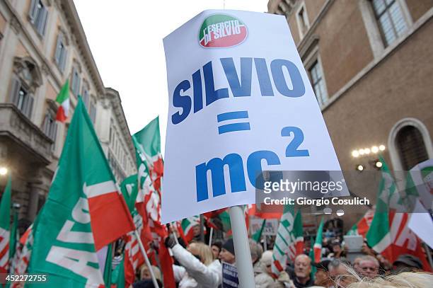 Demonstrators hold flags and banners during a rally in support of former Italian Prime Minister Silvio Berlusconi in front of his house, Palazzo...