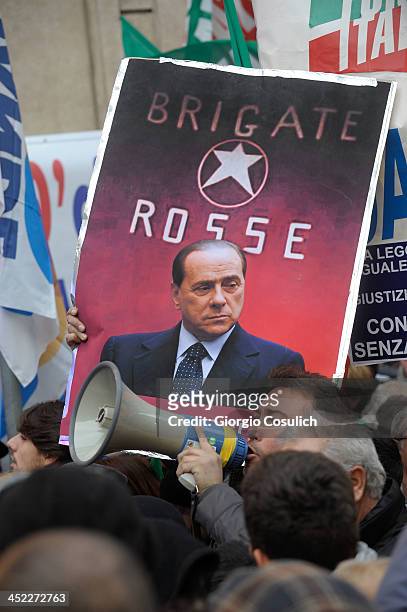 Demonstrator holds a banner featuring Silvio Berlusconi under a 'Red Brigade' star during a rally in support of the former Italian Prime Minister in...