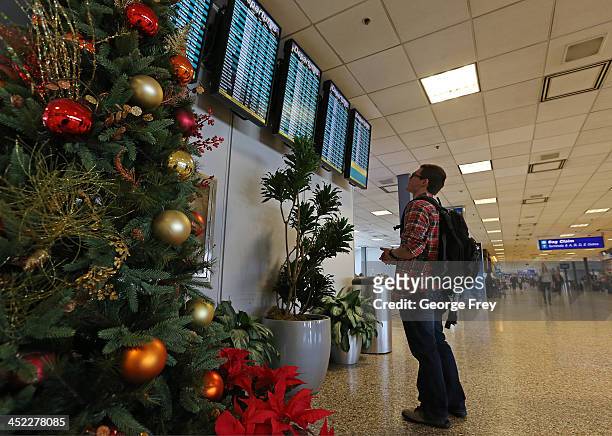 Man looks at an departure board at the Salt Lake City international Airport on November 27, 2013 in Salt Lake City, Utah. A wintry storm system that...