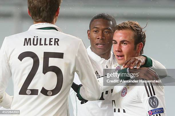 Mario Goetze of Bayern Muenchen celebrates scoring the 2nd team goal with his team mates David Alaba and Thomas Mueller during UEFA Champions League...