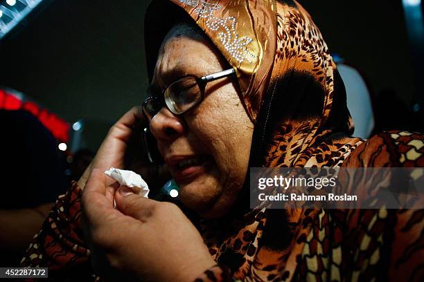 Family member cries as she receives the news of the ill fated flight MH17 on the phone on July 18, 2014 in Kuala Lumpur, Malaysia. Malaysia Airlines...