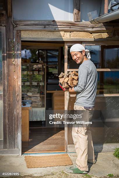 man carrying wood to supply stone oven bakery - wood worker posing ストックフォトと画像