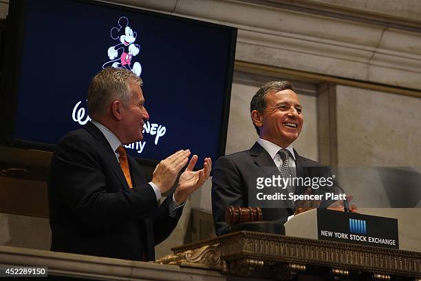 Disney CEO Bob Iger rings the Closing Bell at the New York Stock Exchange as CEO of the New York Stock Exchange Duncan Niederauer applaudes on July...