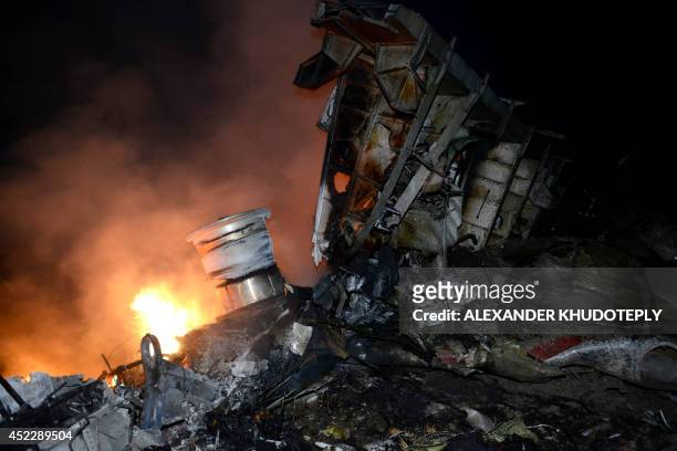 Picture taken on July 17, 2014 shows flames and smoke amongst the wreckages of the malaysian airliner carrying 295 people from Amsterdam to Kuala...