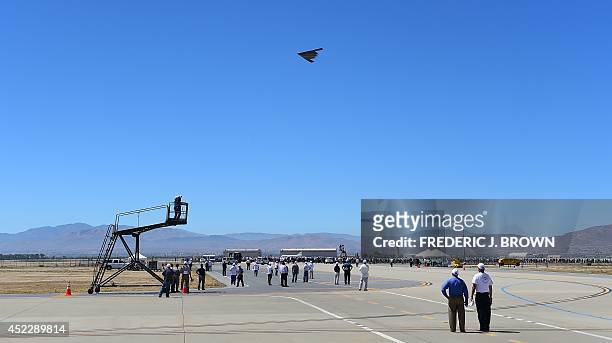 People gather on the tarmac to watch a fly-by of a B-2 Stealth Bomber at the Palmdale Aircraft Integration Center of Excellence in Palmdale,...