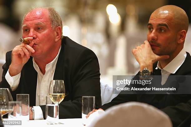 Uli Hoeness, President of Bayern Muenchen enjoys a cigar beside head coach Josep Guardiola during the Champions Dinner at RitzCarlon Hotel Moscow...