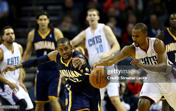 Watson of the Indiana Pacers goes after a loose ball with Ramon Sessions of the Charlotte Bobcats during their game at Time Warner Cable Arena on...