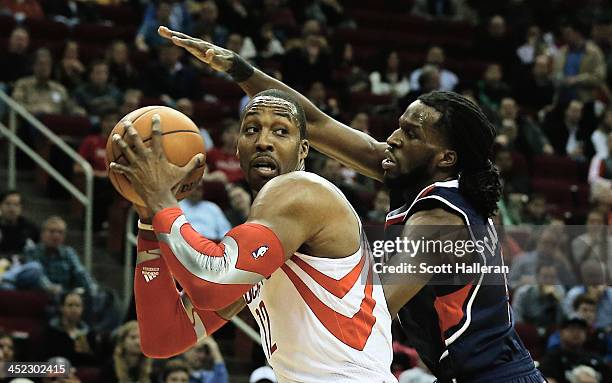 Dwight Howard of the Houston Rockets drives against DeMarre Carroll of the Atlanta Hawks at Toyota Center on November 27, 2013 in Houston, Texas....
