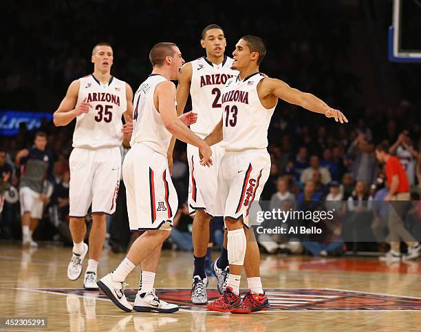 Nick Johnson of the Arizona Wildcats celebrates a basket with T.J. McConnell their Semi Final game of the NIT Season Tip Off against the Drexel...