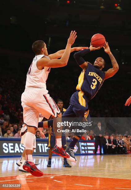 Chris Fouch of the Drexel Dragons shoots against Nick Johnson of the Arizona Wildcats during their Semi Final game of the NIT Season Tip Off at...
