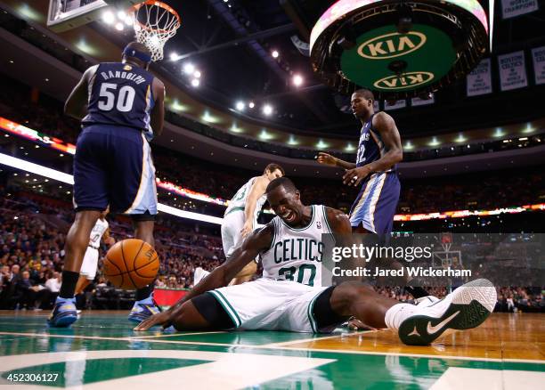 Brandon Bass of the Boston Celtics sits on the court after falling awkwardly for a rebound against the Memphis Grizzlies during the game at TD Garden...