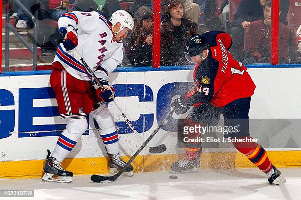 Tomas Fleischmann of the Florida Panthers crosses sticks with John Moore of the New York Rangers at the BB&T Center on November 27, 2013 in Sunrise,...