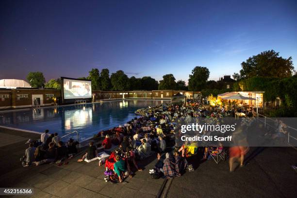 Members of the public watch an outdoor screening of the film 'Jaws' in Brockwell Lido at night on July 17, 2014 in London, England. The outdoor...