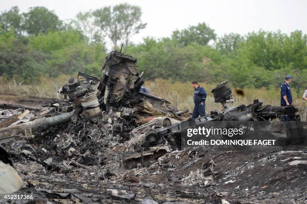 Rescuers stand on July 18, 2014 on the site of the crash of a Malaysian airliner carrying 298 people from Amsterdam to Kuala Lumpur, near the town of...