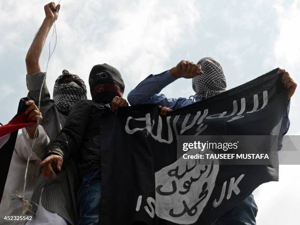 Kashmiri demonstrators hold up a flag of the Islamic State of Iraq and the Levant during a demonstration against Israeli military operations in Gaza,...