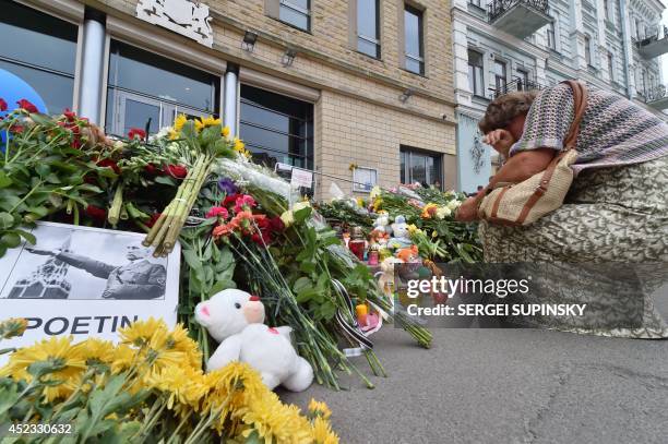 Woman cries as people lay flowers and light candles in front of the Embassy of the Netherlands in Kiev on July 18 to commemorate passengers of...