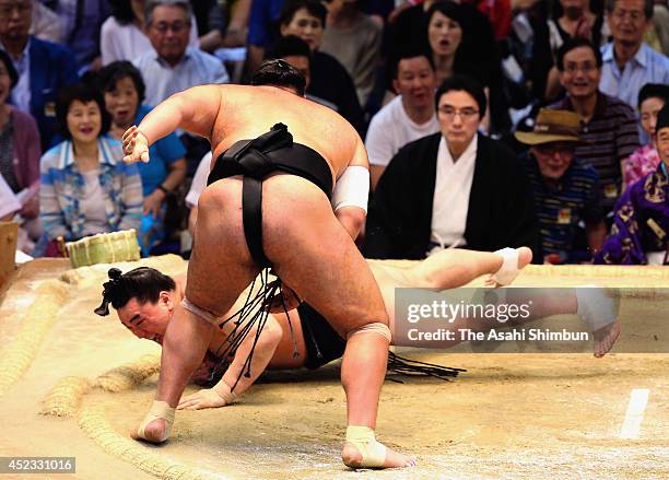 Osunaarashi throws yokozuna Harumafuji to win during day six of the Grand Sumo Nagoya Tournament at Aichi Prefecture Gymnasium on July 18, 2014 in...
