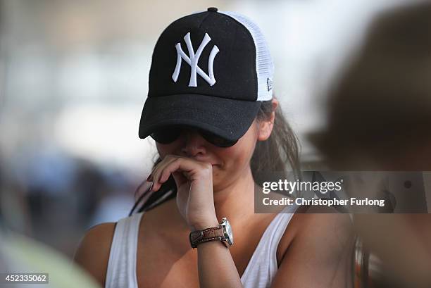 Woman reacts to floral tributes at the entrance to Schiphol Airport in memory of the victims of Malaysia flight MH17 on July 18, 2014 in Amsterdam,...