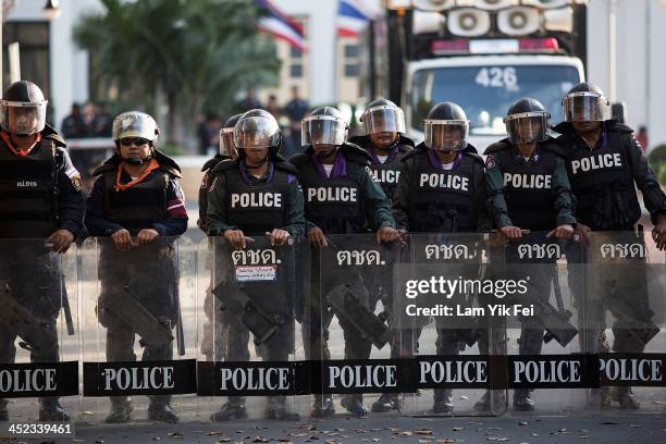 Riot police stand guard as protestors occupy the main road outside the police headquarter on November 28, 2013 in Bangkok, Thailand. Thailand's...