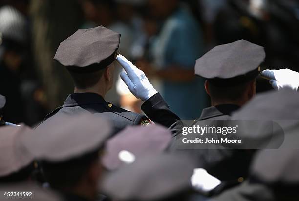 Police salute as the flag-draped coffin of slain Jersey City police officer Melvin Santiago passes by following a funeral mass on July 18, 2014 in...