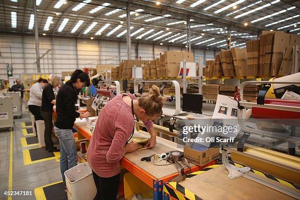 Employees gift wrap items before dispatching them in the huge Amazon 'fulfilment centre' warehouse on November 28, 2013 in Peterborough, England. The...