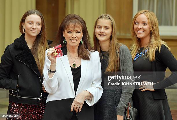 British author Jackie Collins poses for pictures with her granddaughters Dylan Thain, Chloe Green, and India Thain, as she holds her Officer of the...