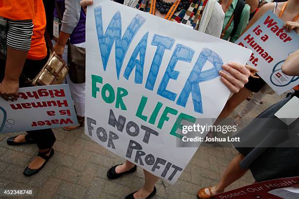 Demonstrators hold signs as they protest against the Detroit Water and Sewer Department July 18, 2014 in Detroit, Michigan. The Detroit Water and...