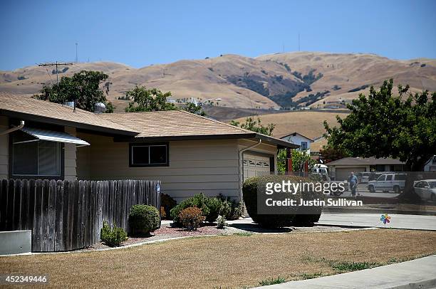 Home with a dead lawn stands in front of hills that are browned with dried grass on July 18, 2014 in Fremont, California. As the severe drought in...